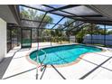 Inviting in-ground pool surrounded by a screened enclosure offering relaxation and privacy at 16249 Ashland Ave, Port Charlotte, FL 33954