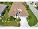 Well maintained single-story home with a brown roof, landscaped yard, and long driveway at 1701 Lastingham Ln, Port Charlotte, FL 33980