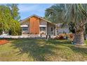 Inviting home featuring a brick accent wall, a screened in porch, and a well-manicured front yard at 17380 Shirley Ave, Port Charlotte, FL 33948