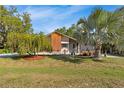 Charming home with mature trees and landscaped front yard, blending curb appeal with a touch of nature at 17380 Shirley Ave, Port Charlotte, FL 33948