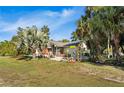 Beautiful home showcasing mature palm trees and lush landscaping creating a private outdoor space at 17380 Shirley Ave, Port Charlotte, FL 33948