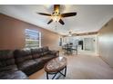 View of the living room and kitchen featuring carpet, ceiling fans and black kitchen appliances at 179 Boundary Blvd # 4, Rotonda West, FL 33947