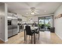 Eat-in kitchen with stainless steel appliances, white cabinetry, tile flooring, and a sliding glass door leading to the lanai at 18417 Ohara Dr, Port Charlotte, FL 33948
