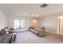Spacious living room featuring tile flooring, neutral paint, large window, and comfortable seating at 18462 Alphonse Cir, Port Charlotte, FL 33948