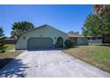 Charming single-story home featuring a long driveway, two-car garage, and mature landscaping at 23051 Elmira Blvd, Punta Gorda, FL 33980