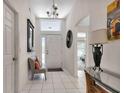 Bright foyer with tile flooring, chandelier, and decor accents, leading to the home's interior at 24055 Buckingham Way, Punta Gorda, FL 33980