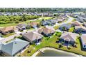 A high-angle shot of a neighborhood with a lush green golf course, pond, and well-maintained homes at 24371 Westgate Blvd, Port Charlotte, FL 33980