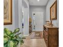 Inviting foyer with tile flooring, neutral paint, elegant decor, and a clear view into the adjacent living space at 24371 Westgate Blvd, Port Charlotte, FL 33980