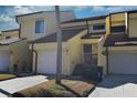Charming yellow townhouse with a one-car garage, a welcoming front porch, and lush landscaping in a vibrant community at 25188 Marion Ave # 1013, Punta Gorda, FL 33950