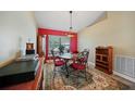 Cozy dining room is accented with red wall, chandelier and decorative rug at 27002 Clear Creek Way, Punta Gorda, FL 33950