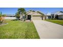 Charming home featuring well-maintained lawn, mature palm trees, and a spacious driveway at 27002 Clear Creek Way, Punta Gorda, FL 33950