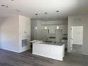 Open-concept kitchen features pendant lighting, white cabinets, and a granite countertop island at 383 Arbor St, Port Charlotte, FL 33953