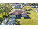 Aerial view of a house with a sprawling lawn, a long driveway, and a glimpse of the neighborhood at 3880 Pinstar Ter, North Port, FL 34287