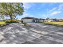 Long concrete driveway with ample parking, leading to a well-kept home with lush greenery in the surrounding yard at 3880 Pinstar Ter, North Port, FL 34287