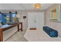Inviting foyer with modern tile flooring, a stylish entry table, and double doors that welcome guests at 3880 Pinstar Ter, North Port, FL 34287
