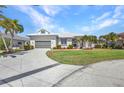Attractive home with a well-kept lawn, landscaping, and a circular paved driveway at 412 Panarea Dr, Punta Gorda, FL 33950