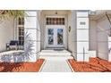 Elegant entryway with decorative glass doors and tiled walkway lined with mulch at 412 Panarea Dr, Punta Gorda, FL 33950