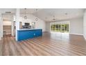 Bright, open-concept living area featuring luxury vinyl plank flooring and a modern kitchen with a stylish island at 422 Ravenswood Blvd, Port Charlotte, FL 33954