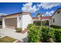 Well-maintained townhome with red tile roof, attached garage, and lush landscaping at 5036 San Rocco Ct, Punta Gorda, FL 33950