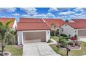 Charming townhomes featuring red tile roofs, inviting walkways, and attached garages at 5036 San Rocco Ct, Punta Gorda, FL 33950