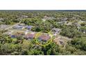 Aerial view of home with screened-in pool surrounded by trees, neighborhoods and roads at 5125 Ariton Rd, North Port, FL 34288