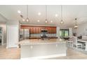 Modern kitchen featuring granite countertops, stainless steel appliances, and an island with pendant lighting at 5125 Ariton Rd, North Port, FL 34288