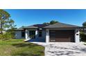 Beautiful home with modern garage door, solar panels and appealing landscaping at 7344 Manthey Ave, North Port, FL 34291