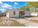 The back of this neutral-painted single-story home is surrounded by a grassy yard with a cracked concrete driveway at 102 21St Ne St, Bradenton, FL 34208