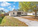 A single-story home featuring neutral paint, a screened-in entryway, and a concrete driveway with a grassy yard at 102 21St Ne St, Bradenton, FL 34208