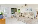 Bright living room with neutral decor, tile flooring, and a large window offering ample natural light at 1345 Harbor Blvd, Port Charlotte, FL 33952