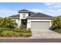 Charming single-Gathering home with a two-car garage, paver driveway, and manicured landscaping at 15931 Sugar Hill Dr, Punta Gorda, FL 33982