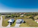 A picturesque aerial view of a home in a vibrant community, surrounded by lush greenery and serene waterways at 17476 Vellum Cir, Punta Gorda, FL 33955