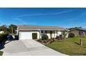 Lovely single-story home featuring an attached garage, neat landscaping, and a green front lawn at 18427 Goodman Cir, Port Charlotte, FL 33948