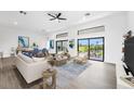 Bright living room with contemporary furnishings, high ceilings, and seamless indoor-outdoor flow to a covered patio at 24259 Peppercorn Rd, Punta Gorda, FL 33955