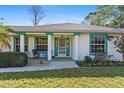 Inviting front porch featuring white columns, colorful accents, and comfortable seating, creating a welcoming entrance at 2631 Tomaso Rd, North Port, FL 34287