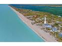 Majestic oceanfront house with direct beach access, surrounded by lush, tropical landscapes at 6112 Gnarled Oak Dr, Englewood, FL 34223