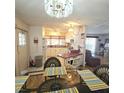 Open-concept dining area with table, chairs, lighting, and seamless flow to the kitchen and living areas at 715 Fairmount Dr, North Port, FL 34287