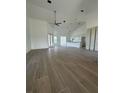 Spacious living room featuring sleek wood-look tile flooring, high ceilings, and ample natural light at 8136 Sweden Blvd, Punta Gorda, FL 33982