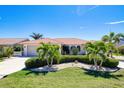 Charming one story home featuring a spanish tile roof, lush landscaping, and a two car garage at 815 Via Formia, Punta Gorda, FL 33950