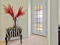 Foyer features a decorative glass door, tile flooring, and a unique accent table with a flower arrangement at 9020 Eagle Bay Ct, North Port, FL 34287