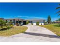 Single-story home featuring a tile roof and circular driveway surrounded by a well-maintained lawn and mature landscaping at 1206 Winward Ct, Punta Gorda, FL 33950