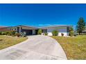 Single-story home featuring a tile roof and circular driveway surrounded by a well-maintained lawn and mature landscaping at 1206 Winward Ct, Punta Gorda, FL 33950