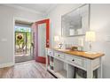 Inviting entryway featuring decorative console table with decor, and a red door leading to the outside at 15288 Mille Fiore Blvd, Port Charlotte, FL 33953