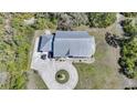 An aerial perspective of a home showcasing its pristine metal roof, circular driveway, and manicured lawn at 16180 Forest Glen Ct, Punta Gorda, FL 33982