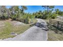 A private driveway bordered by a rustic wooden fence, leading to a secluded property at 16180 Forest Glen Ct, Punta Gorda, FL 33982