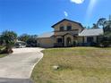 Two-story home featuring a driveway, a well-manicured lawn, and a welcoming facade at 18267 Grace Ave, Port Charlotte, FL 33948