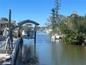 A clear canal view with boats docked and boat lift, highlighting the waterfront property at 2061 S Pine St, Englewood, FL 34224