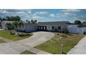 Desirable home with long driveway, attached garage, and lush lawn, enhanced by vibrant blue trim and landscaping at 234 Tait Se Ter, Port Charlotte, FL 33952