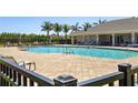 Community pool with lounge chairs and palm trees, perfect for relaxation at 25292 E Lenox Cir, Punta Gorda, FL 33950