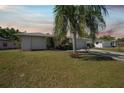 Charming one-story home showcasing a manicured lawn and mature palm, offering inviting curb appeal with its long driveway at 3753 Aba Ln, North Port, FL 34287
